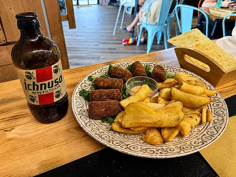 Aperitivo con crocchette, patatine fritte e birra sarda